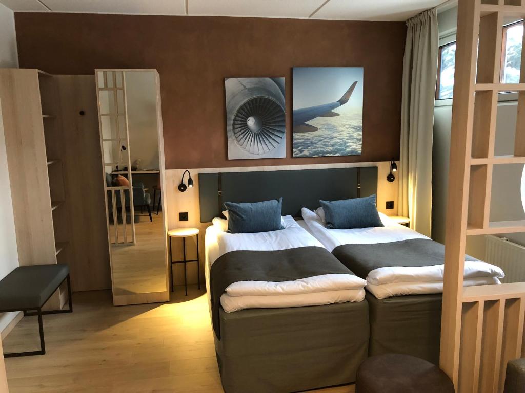 a bedroom with two beds and a view into a room at Pilot Airport Hotel in Vantaa