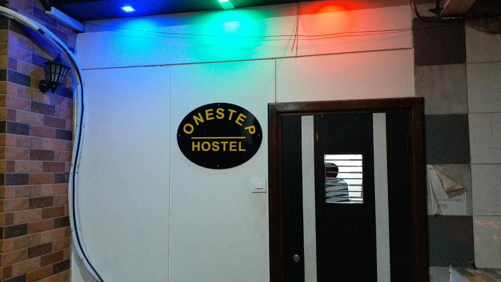 une chambre avec un panneau sur le mur à côté d'une porte dans l'établissement One Step Hostel, à Mumbai