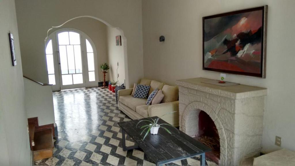 een woonkamer met een bank en een open haard bij Cozy and Comfortable Home in MIRAFLORES in Lima
