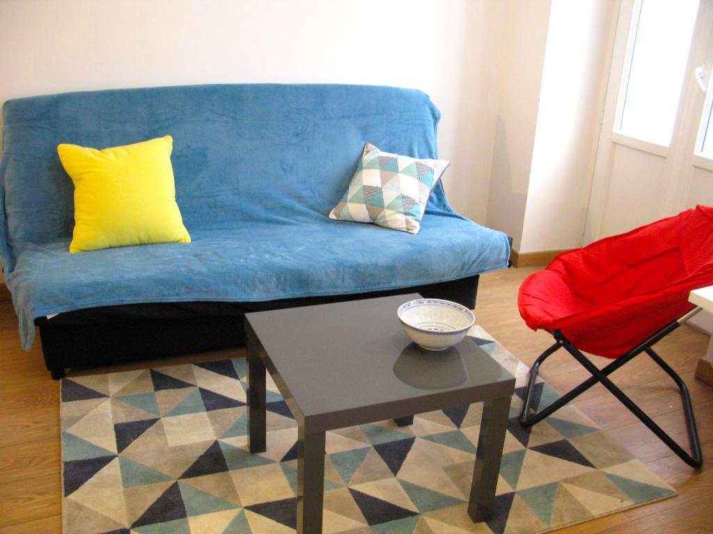 un salon avec un canapé bleu et une table dans l'établissement Place Wilson, à Nice