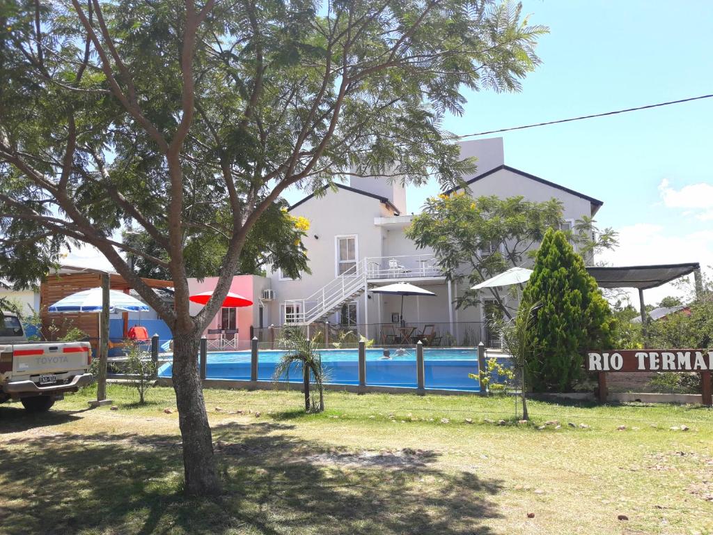 a tree in front of a building with a swimming pool at Rio Termal in Federación