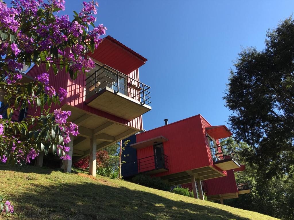 un bâtiment sur une colline avec des fleurs violettes dans l'établissement Latitude Lodge, à Cunha