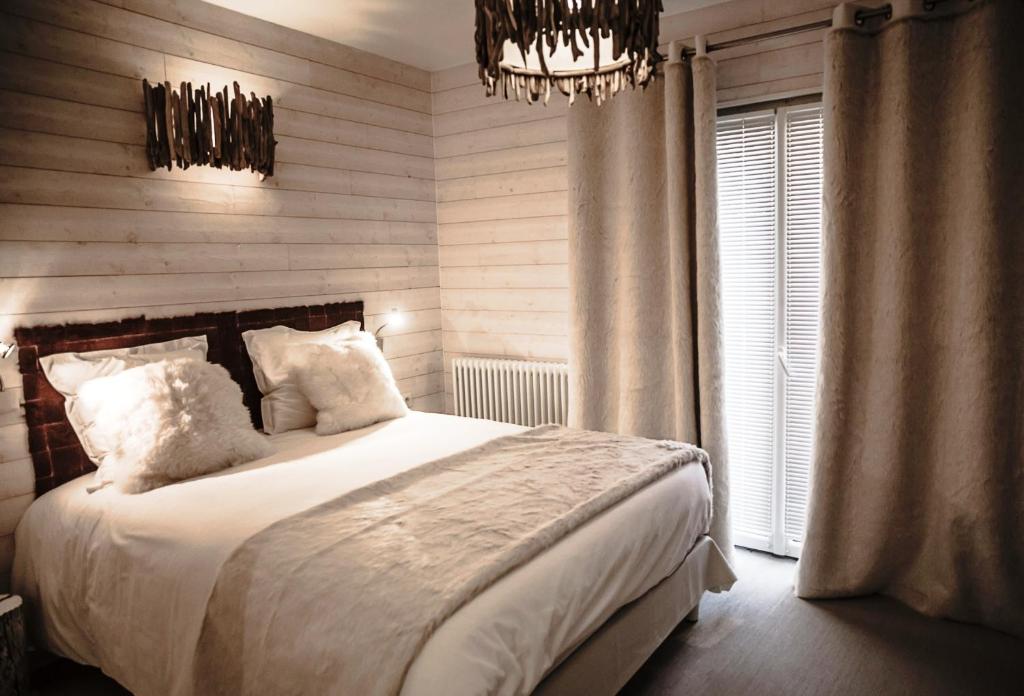 a bedroom with a bed and a chandelier at Rock Noir & Spa in La Salle-les-Alpes