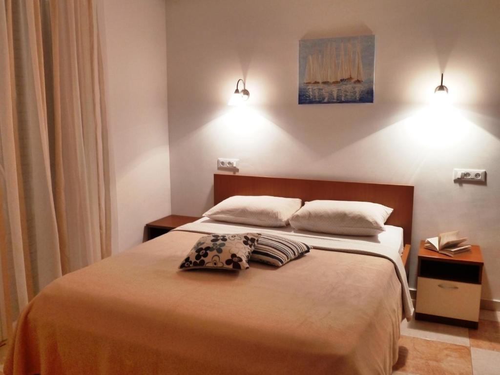 a bedroom with a bed with two pillows on it at Nice Apartment & Room in Cavtat in Cavtat