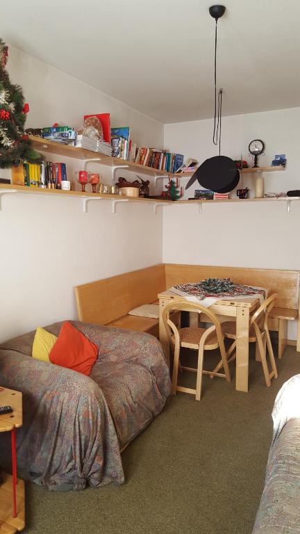 - un salon avec un lit et une table dans l'établissement Grazioso appartamento in casa di montagna a San Vito di Cadore, à San Vito di Cadore