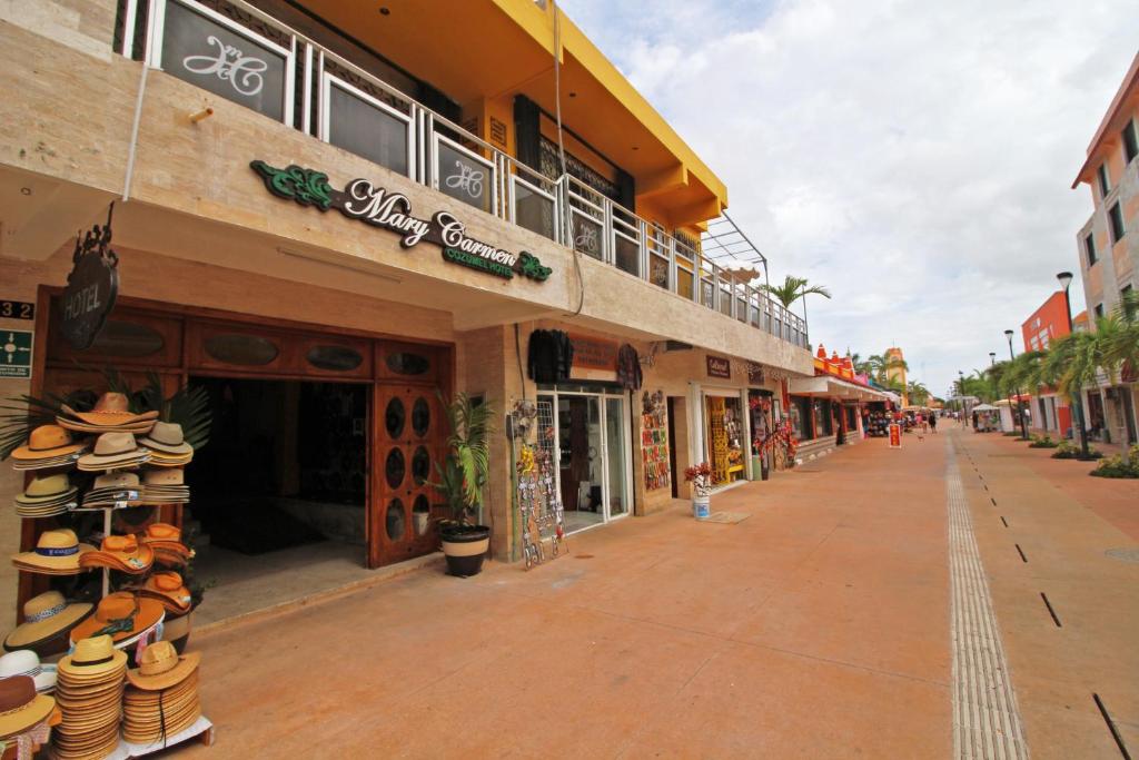 une rue avec des boutiques sur le côté d'un bâtiment dans l'établissement Hotel Mary Carmen, à Cozumel