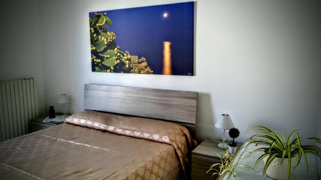 una camera con un letto e una foto appesa al muro di B&B Delfis II a Gallipoli