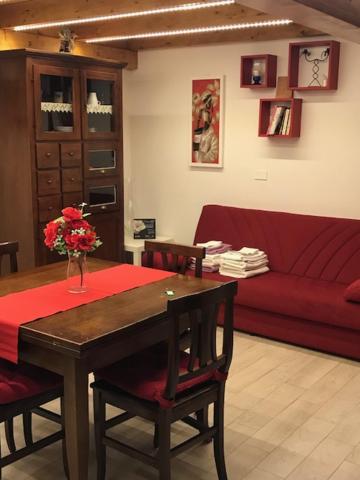 salon ze stołem i czerwoną kanapą w obiekcie Casa vacanze Albano w mieście Albano Laziale