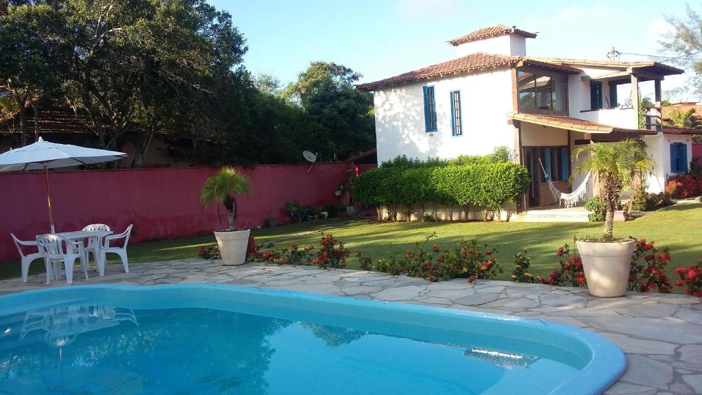 a swimming pool in front of a house at Linda Casa em Búzios in Búzios