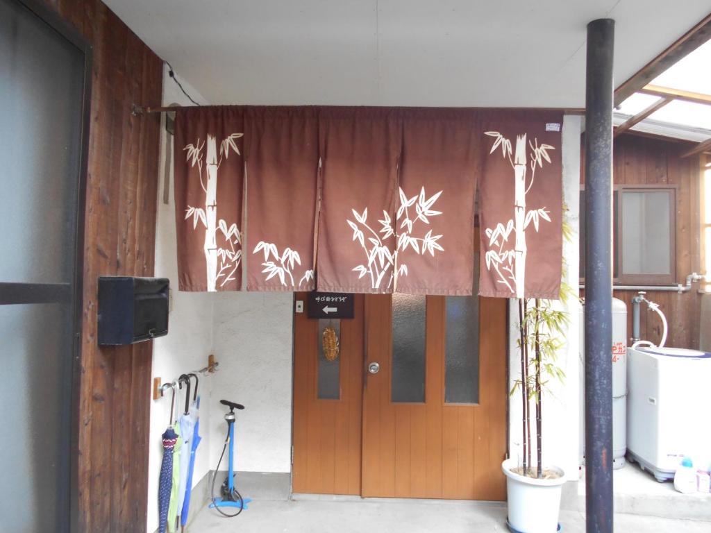 una cortina está colgando sobre una puerta en un edificio en Minshuku Takenoya, en Naoshima