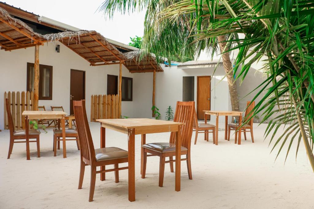 un grupo de mesas y sillas en un patio en The Castaway retreat en Feridhoo