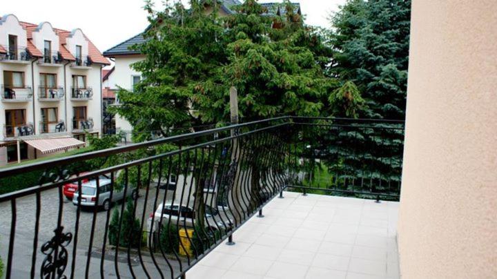 a balcony with a view of a street with cars at Dom Wczasowy Mateusz in Rewal