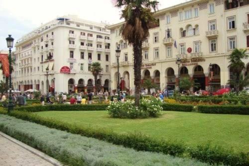 a large building with a green lawn in front of it at Aristotelous Square Luxury Apartment in Thessaloniki