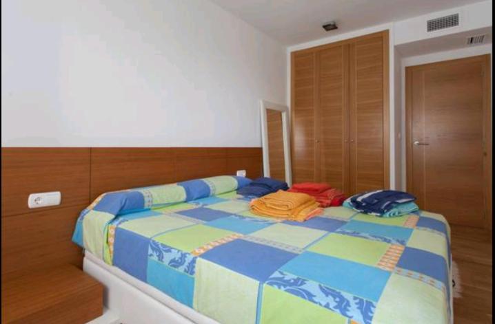 sypialnia z łóżkiem z ubraniami w obiekcie Relax, sol y playa w mieście El Campello