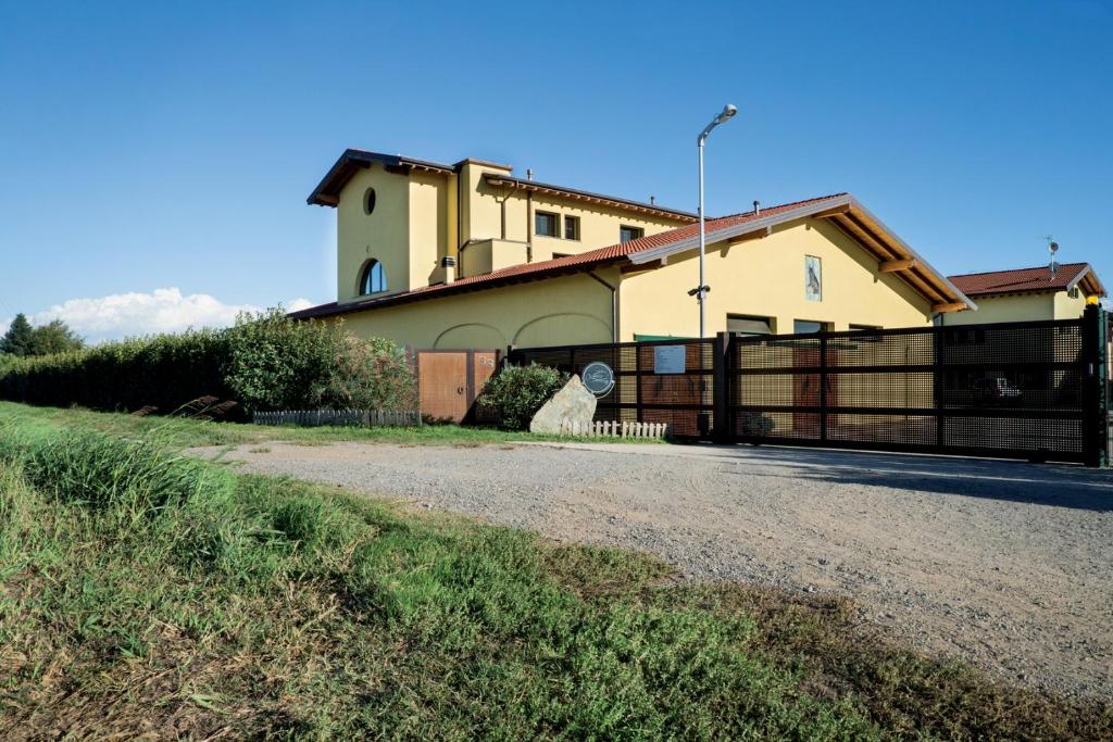 a house with a fence in front of it at Agriturismo Camisi qh in Cambiago