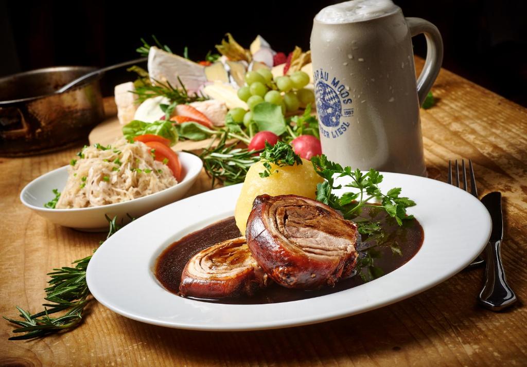 une assiette de nourriture avec de la viande et une salade sur une table dans l'établissement Hotel Gäubodenhof, à Straubing