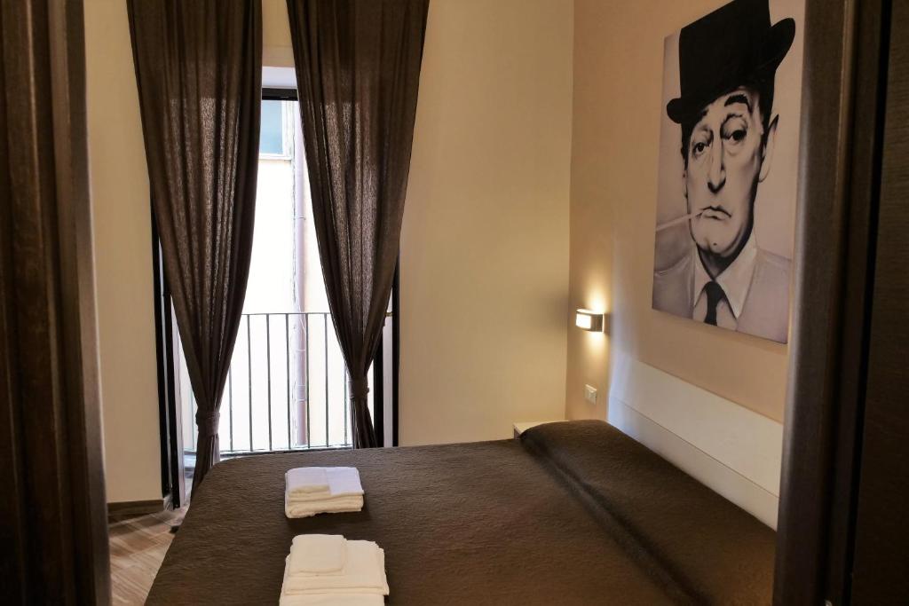- une chambre avec un lit orné d'une peinture d'homme dans l'établissement B&B Il Campanile, à Naples