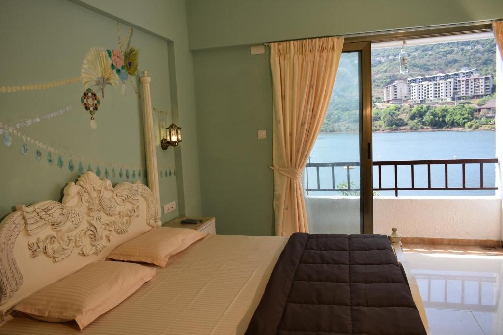 a bedroom with a bed with a view of the water at Lavasa Holiday Home (Lakeview) in Lavasa