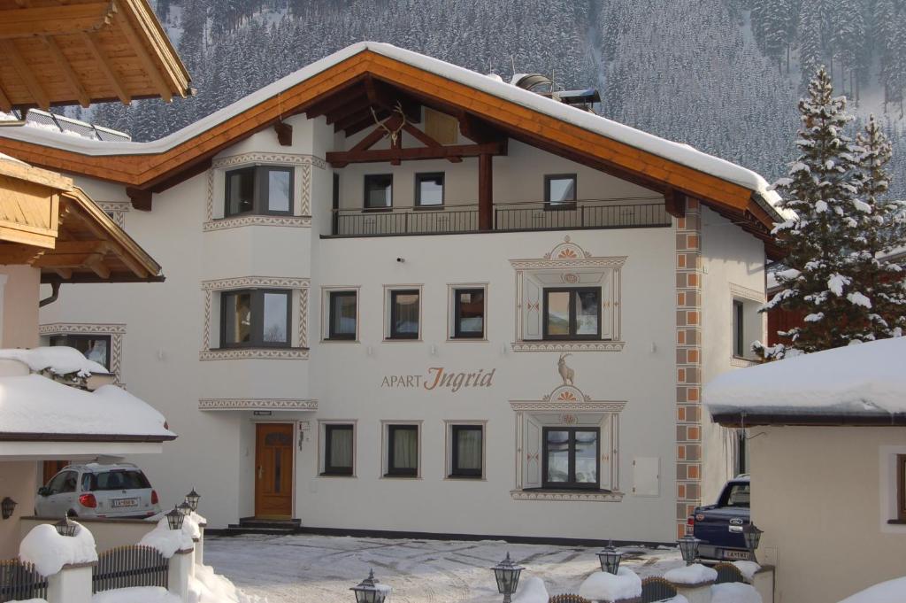 dom w górach z śniegiem na ziemi w obiekcie Apart Ingrid w mieście Ischgl