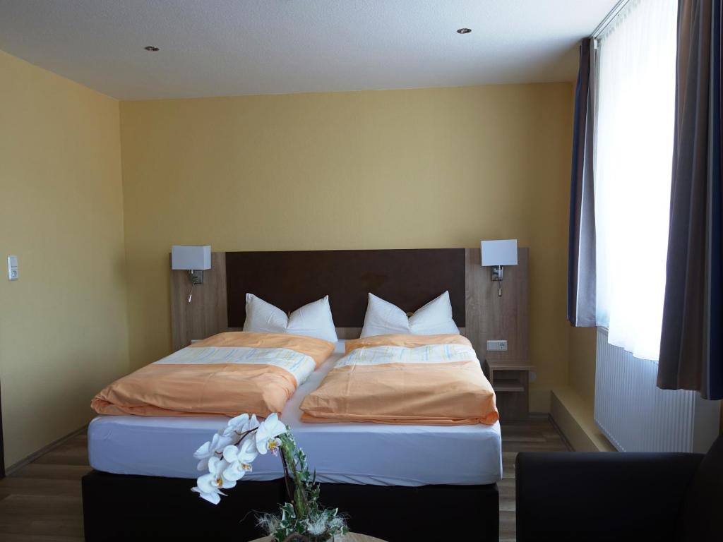 una camera da letto con un grande letto con due cuscini di Wolthusen a Emden
