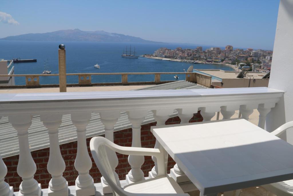 een wit balkon met een tafel en uitzicht op het water bij Tarace sea view apartment in Sarandë