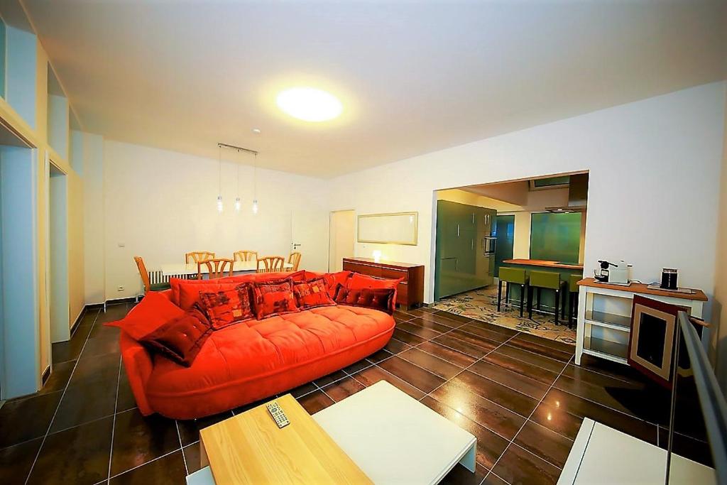 a living room with a red couch and a table at Connie's House Holiday Apartment in Heidelberg