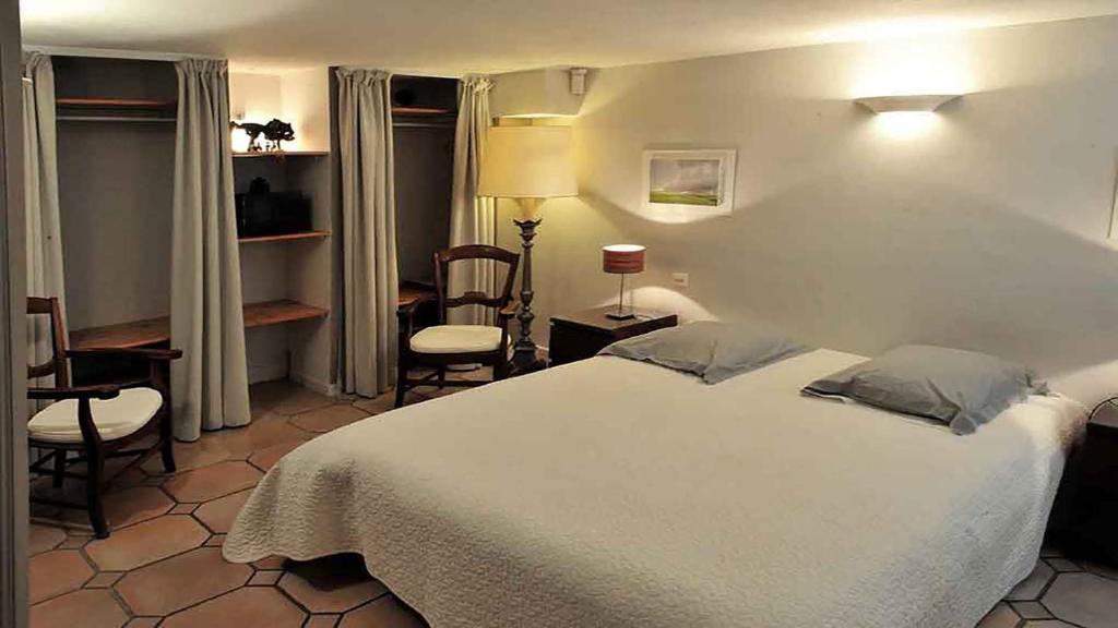 - une chambre avec un lit blanc, une table et des chaises dans l'établissement "La Valériane", à Grasse