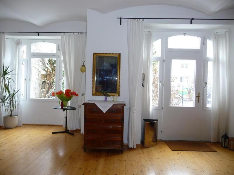 a room with two windows and a dresser with a mirror at Studio Währing in Vienna