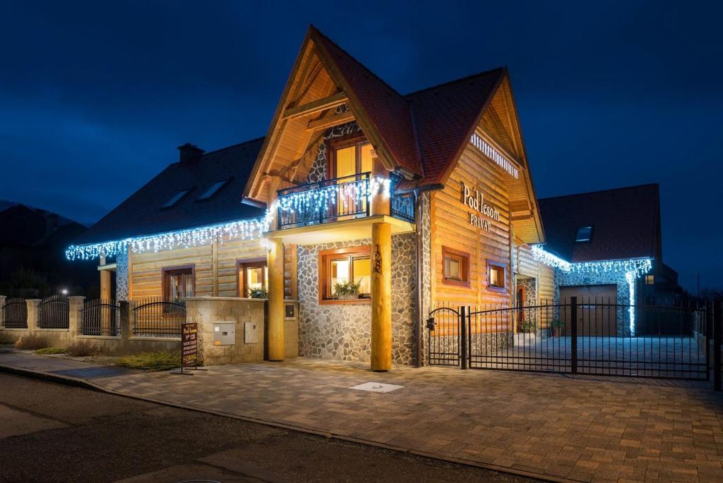 ein nachts beleuchtetes Haus mit Lichtern in der Unterkunft Guest House Privat Pod Lesom in Pavčina Lehota