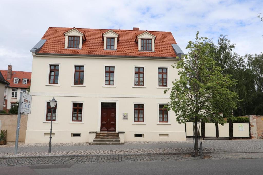 um grande edifício branco com um telhado vermelho em Zimmervermietung Barth em Bernburg