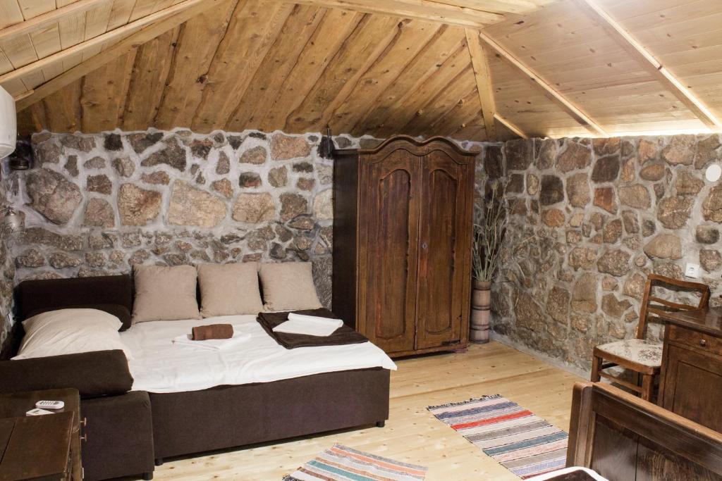 een slaapkamer met een groot bed in een stenen muur bij Solovi Dvori in Karlobag