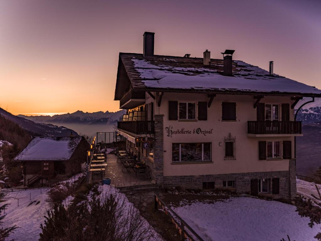 a building with snow on the roof of it at Hostellerie d'Orzival in Vercorin