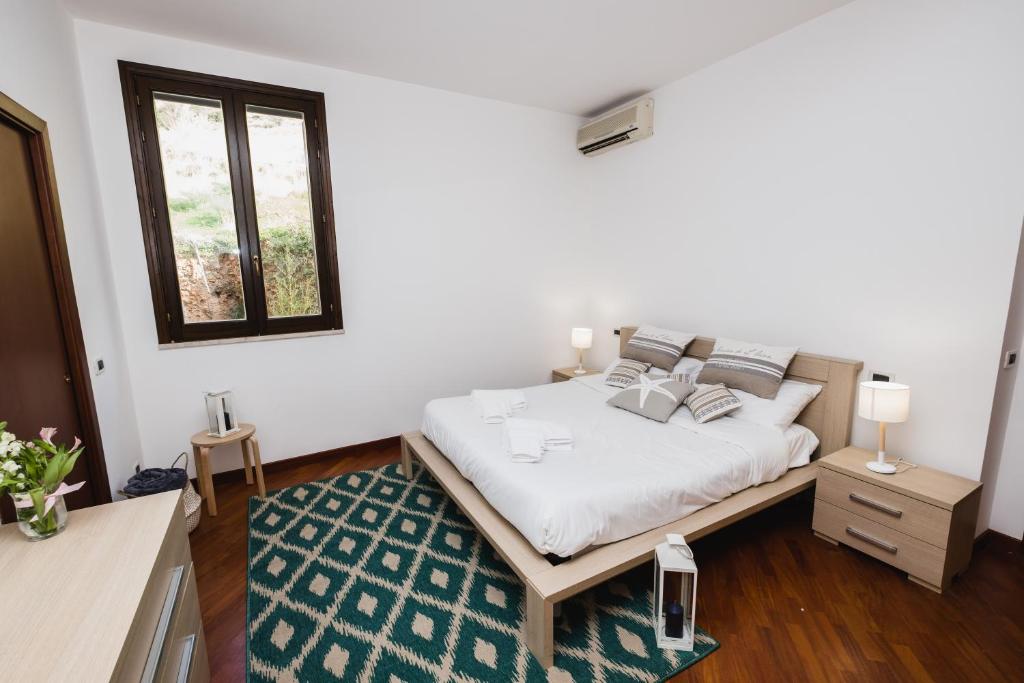 モンデッロにあるLuminHouse Mondello Limoneのベッドルーム1室(緑の敷物が敷かれた白いベッド1台付)