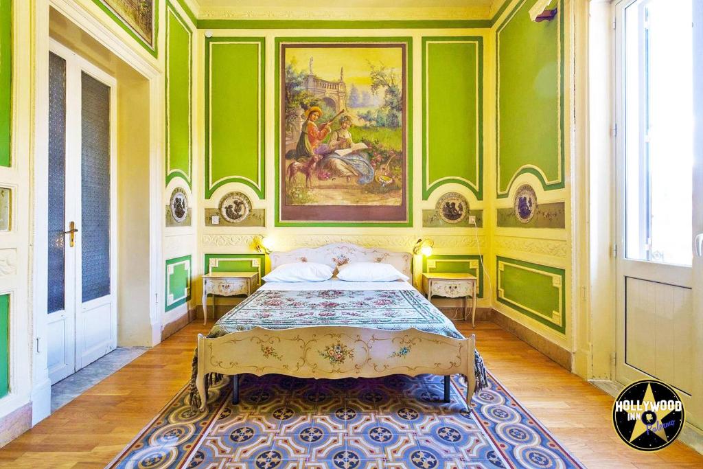 a bedroom with a bed and a painting on the wall at Hollywood Inn Palermo in Palermo