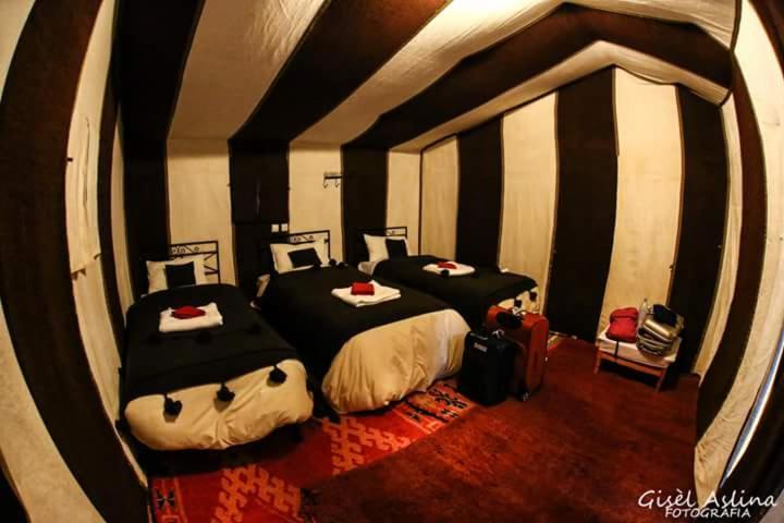 Habitación con 2 camas en una habitación con: en Bivouac Les Clés de Desert, en Adrouine