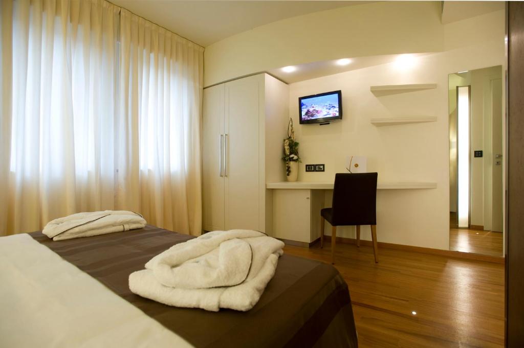ein Schlafzimmer mit einem Bett mit weißen Handtüchern darauf in der Unterkunft Hotel Napoleon in Cherasco
