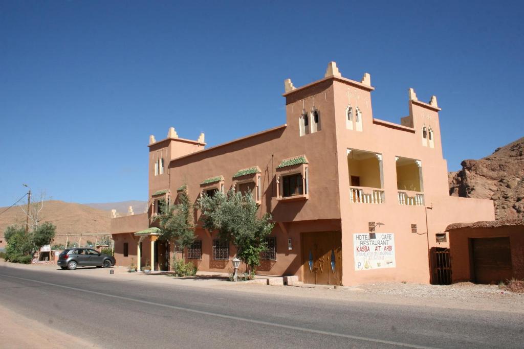 a building on the side of a street in a desert at kasbah Ait arbi in Aït Ougliff