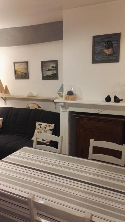 un salon avec un lit et un canapé dans l'établissement L'Estacade : maison de pecheur, à Saint-Valery-sur-Somme