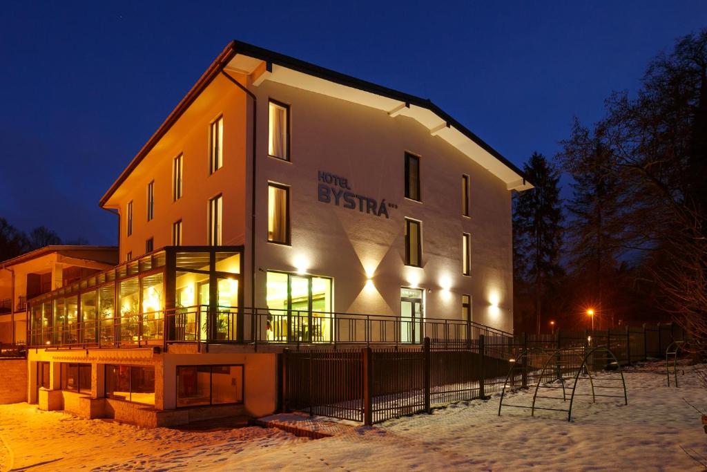ein großes Gebäude im Schnee in der Nacht in der Unterkunft Hotel Bystrá in Snina