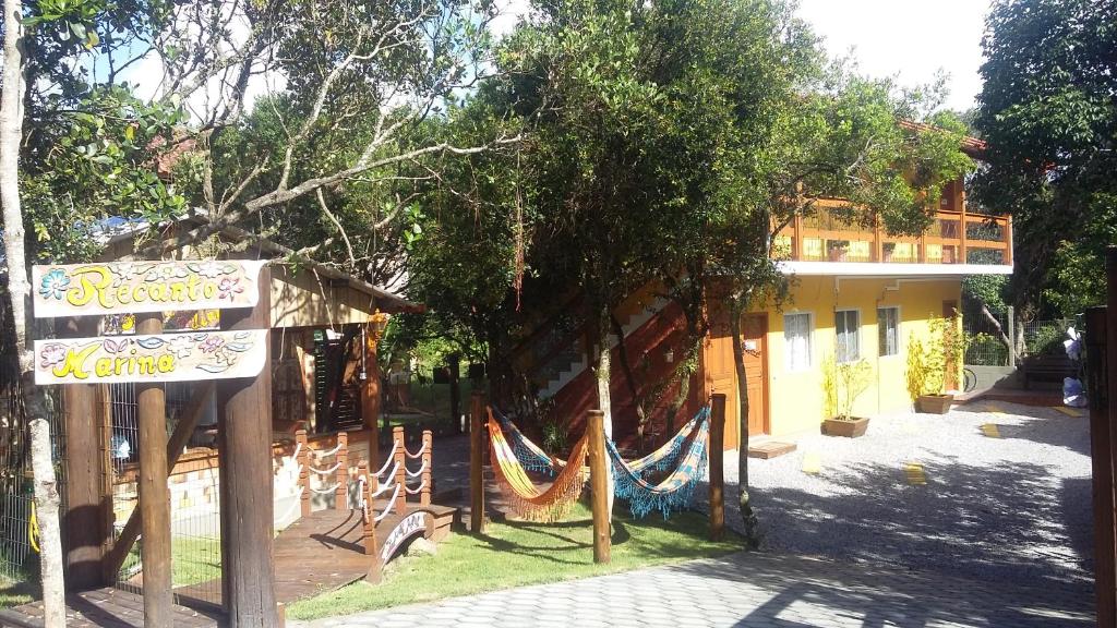 a sign and a hammock in front of a building at Recanto Marina in Guarda do Embaú