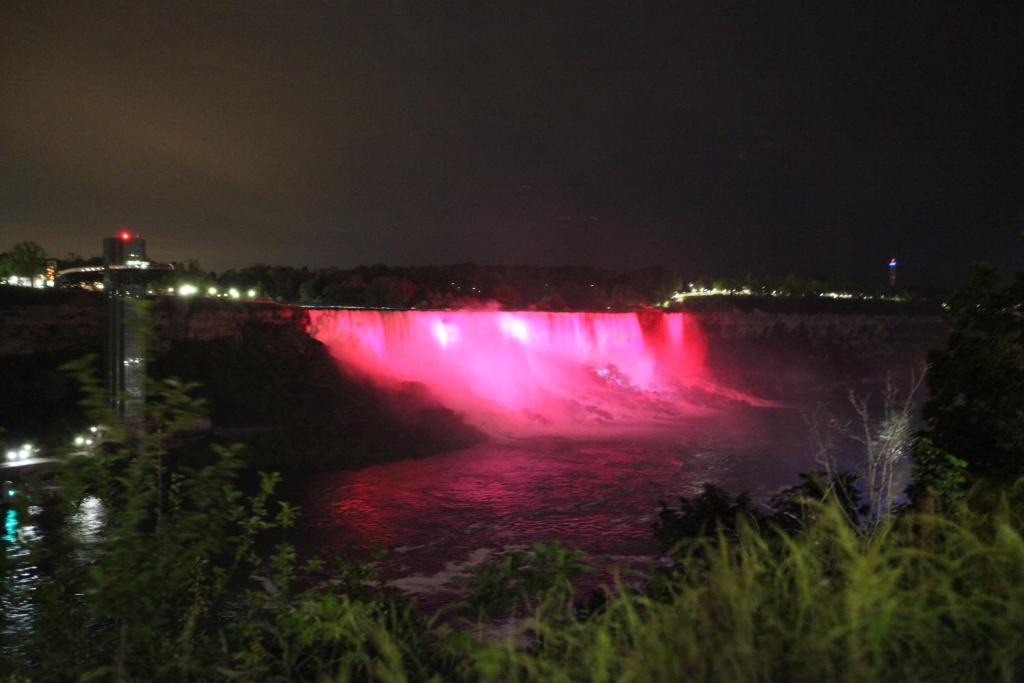 a waterfall lit up at night with red lights at Ambiance By The Falls B&B in Niagara Falls