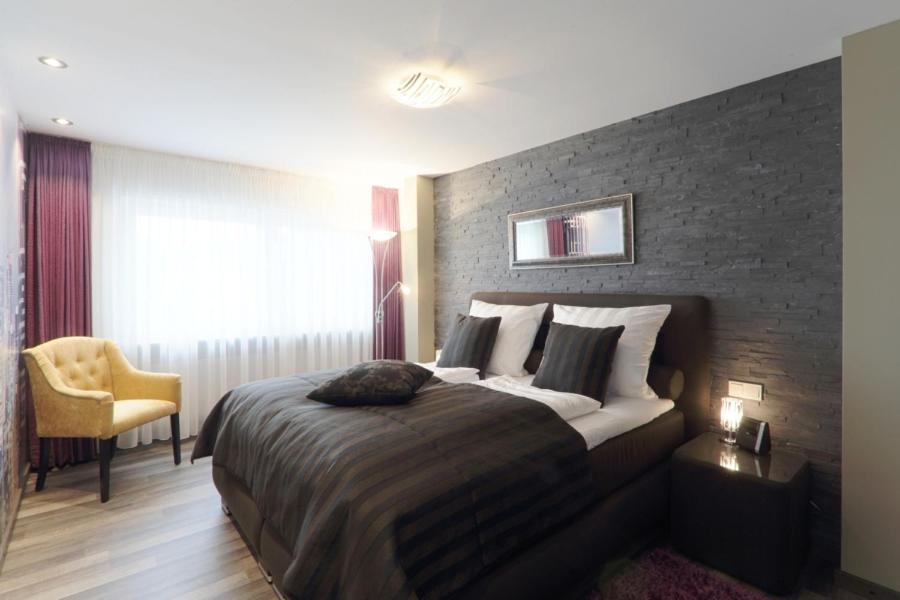 una camera con un grande letto con un muro di mattoni di Ferienwohnung Welcome mit Seeblick a Schalkenmehren