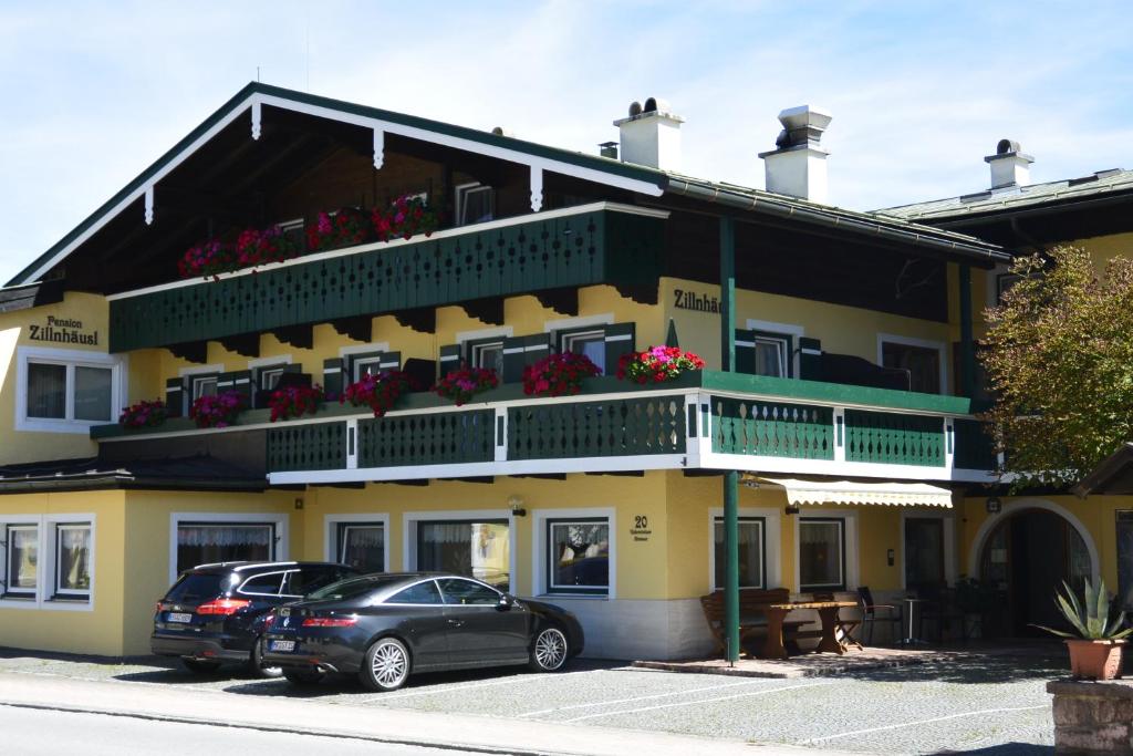 ein gelbes Gebäude mit einem davor geparkt in der Unterkunft Pension Zillnhäusl in Schönau am Königssee