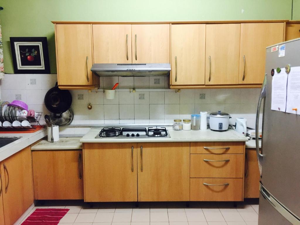 a kitchen with wooden cabinets and a stove top oven at Aziym Homestay@Bandar Baru Bangi in Kampong Tangkas
