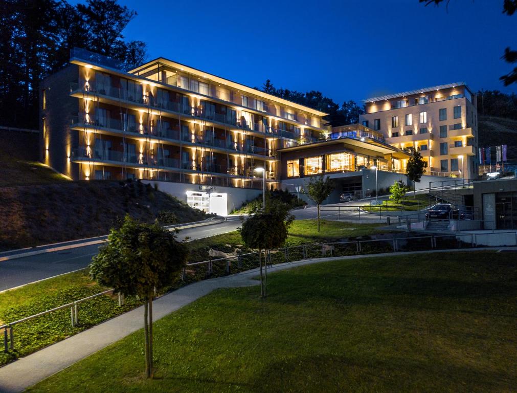 a large building with lights on in a park at Atlantida Boutique Hotel in Rogaška Slatina