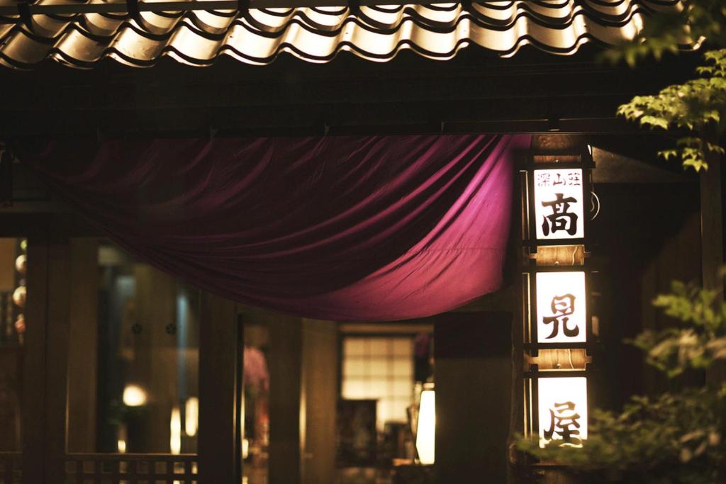 ein Gebäude mit Markise und einem lila Vorhang darauf in der Unterkunft Takamiya Ryokan Miyamaso in Zao Onsen