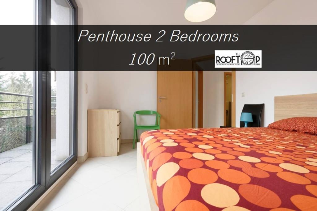 a bedroom with a bed with an orange and white bedspread at Rooftop Luxembourg Ville in Luxembourg