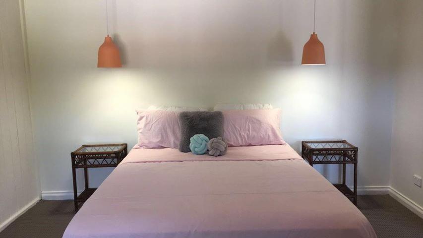 ein Schlafzimmer mit einem großen Bett mit zwei Nachttischen in der Unterkunft Capel Short-Stay Accommodation in Capel