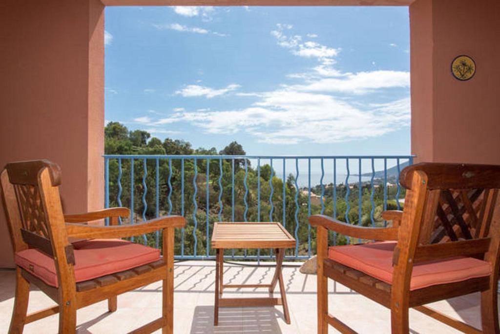 two chairs and a table on a balcony with a view at Rochemarine in Théoule-sur-Mer
