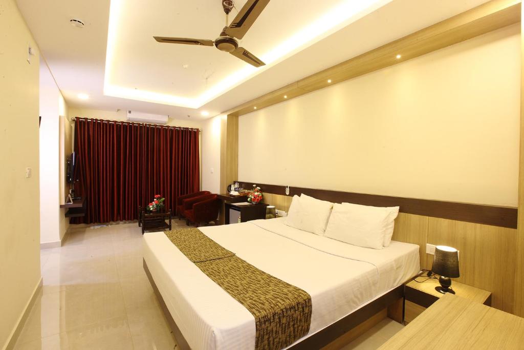 a hotel room with a bed and a ceiling at Trichur Towers in Trichūr